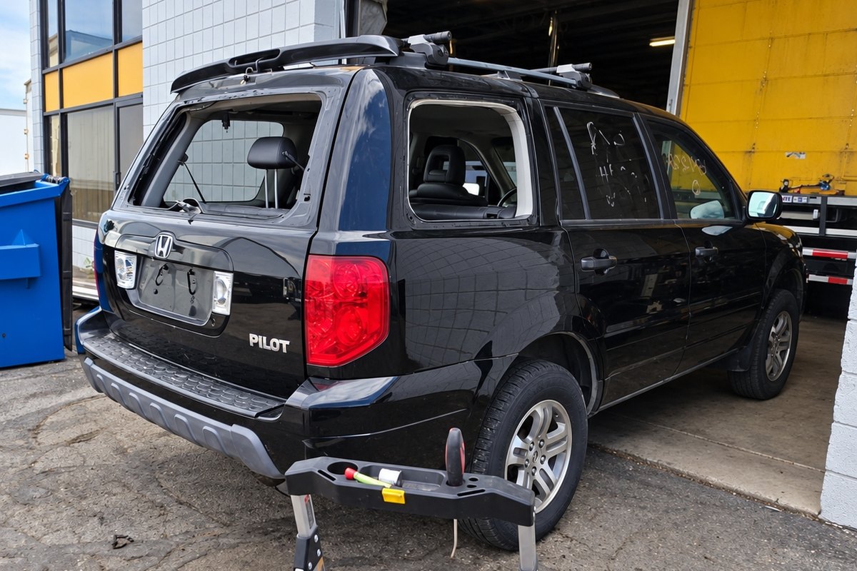 Black Honda Pilot from the rear three-quarter view with its back glass out