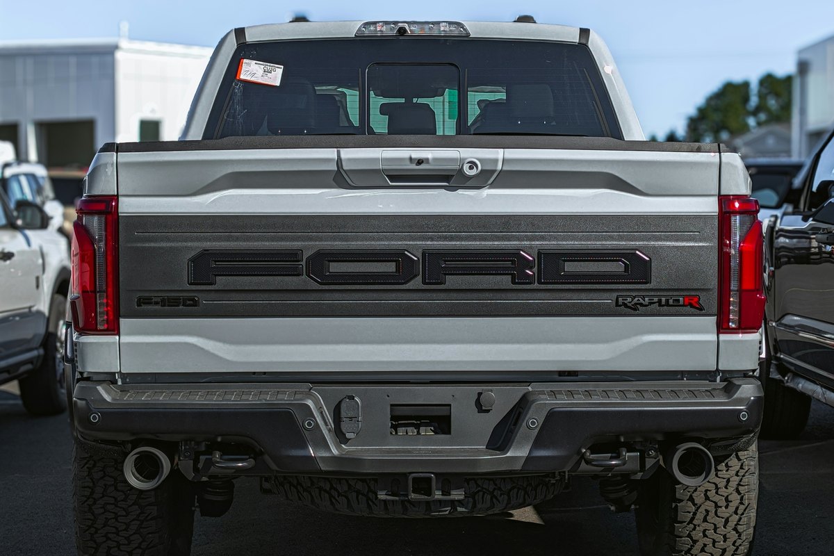 Tailgate of a gray Ford F-150 Raptor pickup with its handle and camera at the top