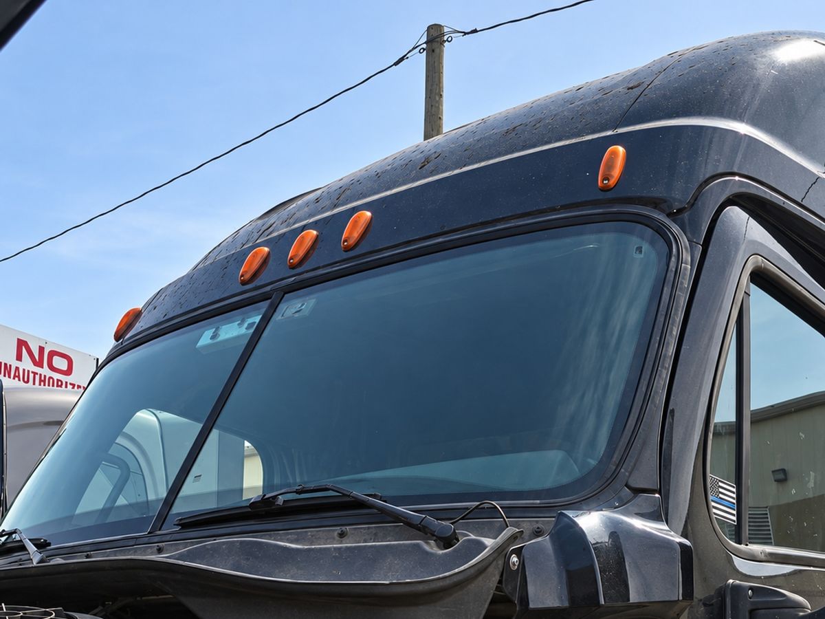 Black cab with a clean two-piece windshield, amber roof lights and raindrops on the roof cap